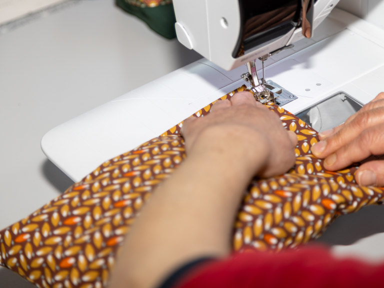 Textile Näharbeiten im Nähatelier mit Industrienähmaschine und Serienfertigung