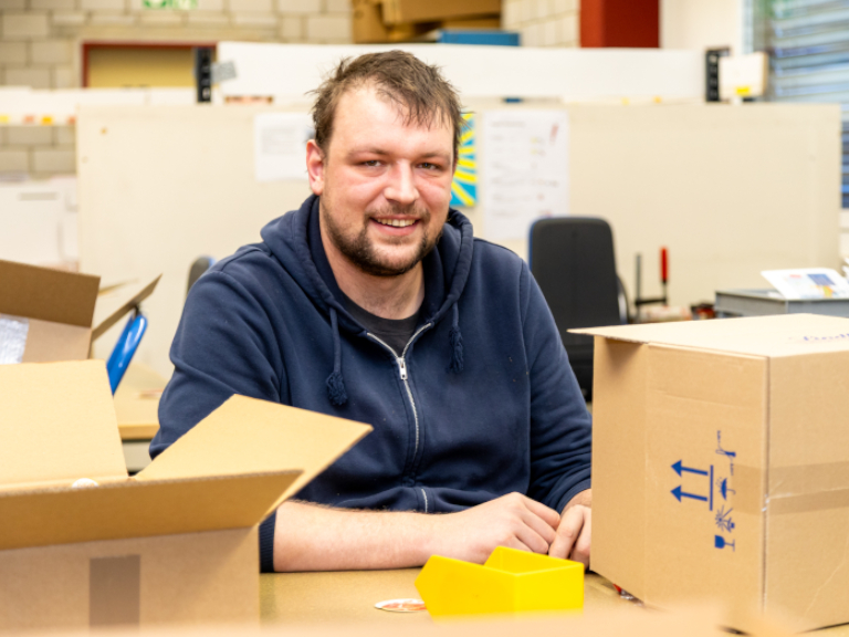 Verpackungsmitarbeiter im Logistikbetrieb bei der sorgfältigen Versandabwicklung